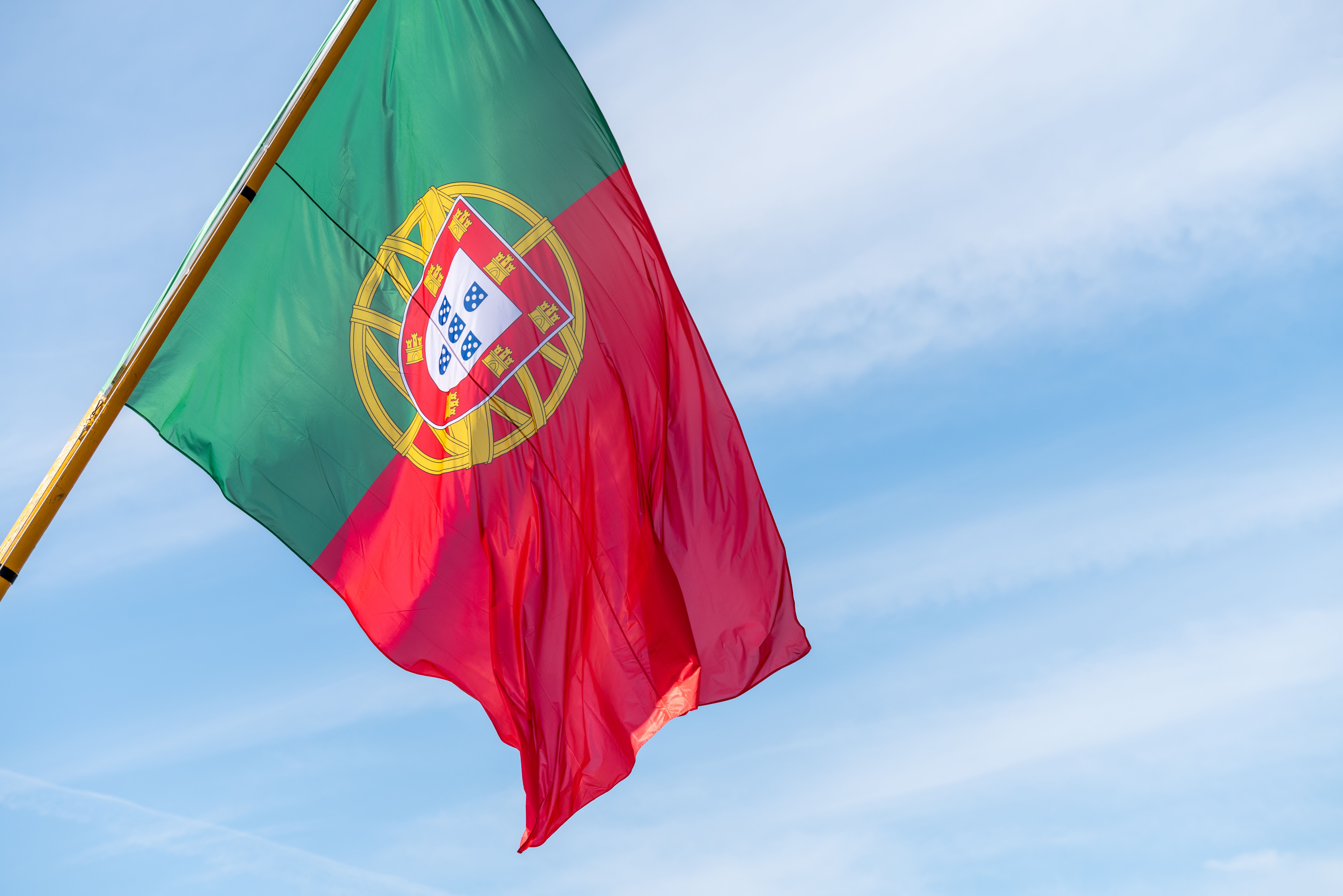 Bandeira de Portugal estendida sob um céu azul