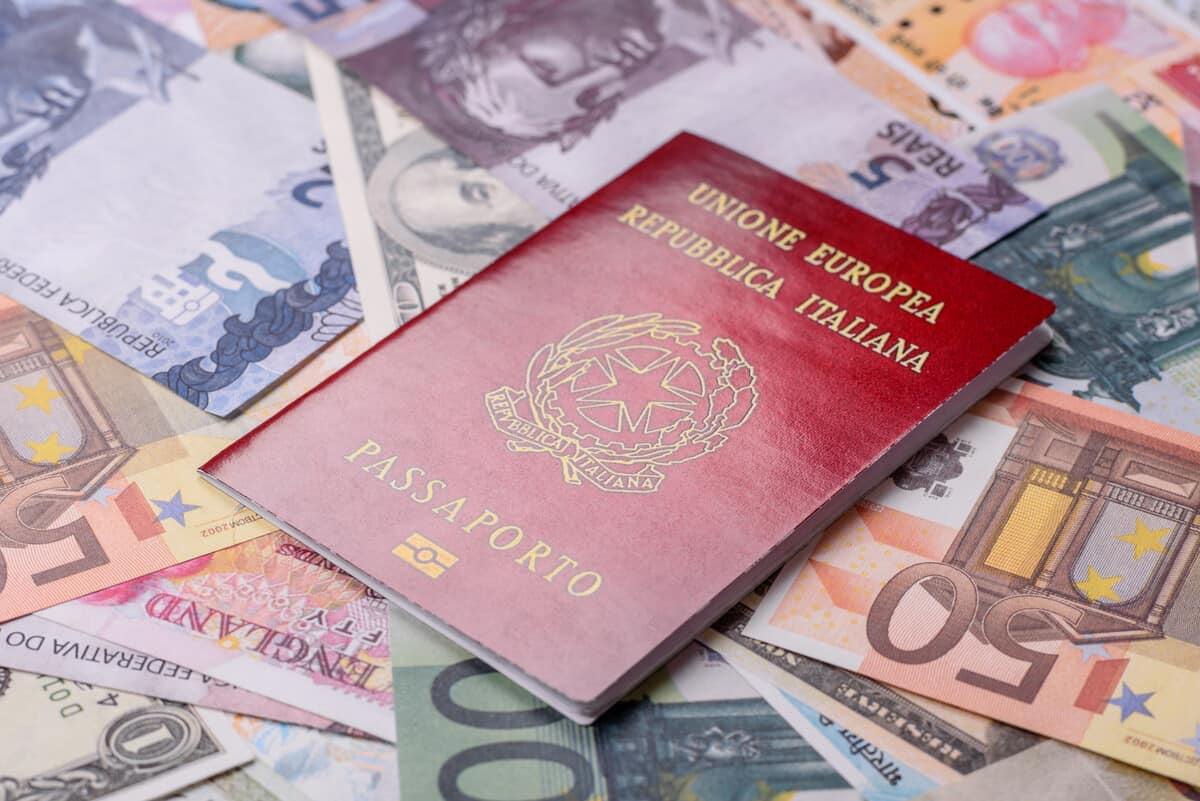 Passaporte italiana em cima de várias notas de dinheiro. 7 motivos para tirar sua cidadania italiana e expandir suas oportunidades na Europa