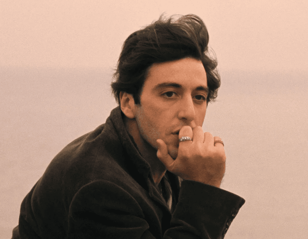 Foto do ator ítalo-americano Al Pacino, com a mão em seu queixo, olhando para a paisagem enquanto navega em uma embarcação.