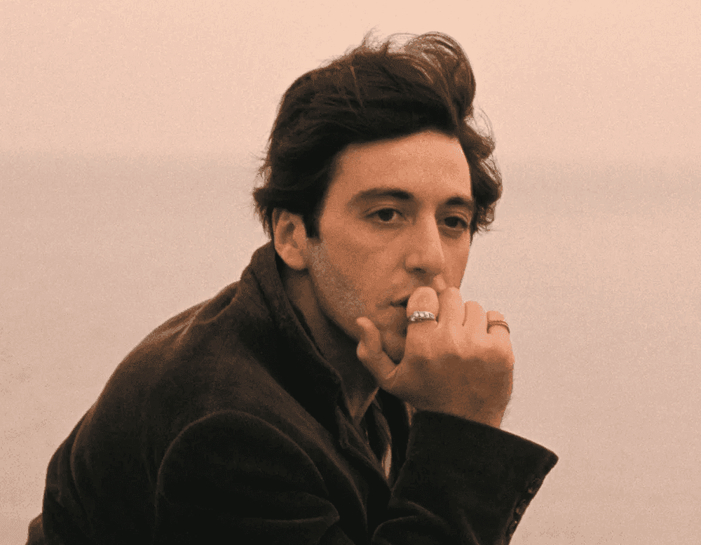 Foto do ator ítalo-americano Al Pacino, com a mão em seu queixo, olhando para a paisagem enquanto navega em uma embarcação.