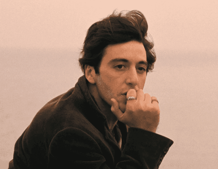Foto do ator ítalo-americano Al Pacino, com a mão em seu queixo, olhando para a paisagem enquanto navega em uma embarcação.